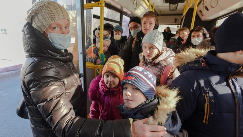 Orang-orang dari wilayah Donetsk dan Luhansk, wilayah yang dikuasai oleh pemerintah separatis pro-Rusia di Ukraina timur, berjalan kaki dari kereta api untuk dibawa ke tempat tinggal sementara di wilayah Volgograd, di stasiun kereta api di Volzhsky, wilayah Volgograd, Rusia, pada Minggu, 20 Februari 2022. (REUTERS/VLADIMIR LAVROV)