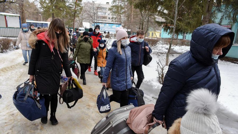 Orang-orang dari wilayah Donetsk dan Luhansk, wilayah yang dikuasai oleh pemerintah separatis pro-Rusia di Ukraina timur, berjalan kaki dari kereta api untuk dibawa ke tempat tinggal sementara di wilayah Volgograd, di stasiun kereta api di Volzhsky, wilayah Volgograd, Rusia, pada Minggu, 20 Februari 2022. (REUTERS/VLADIMIR LAVROV)
