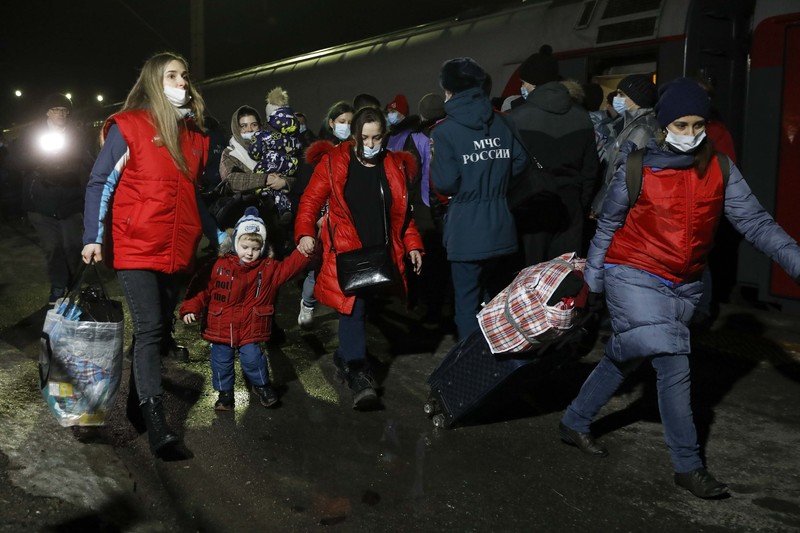 Orang-orang dari wilayah Donetsk dan Luhansk, wilayah yang dikuasai oleh pemerintah separatis pro-Rusia di Ukraina timur, berjalan kaki dari kereta api untuk dibawa ke tempat tinggal sementara di wilayah Volgograd, di stasiun kereta api di Volzhsky, wilayah Volgograd, Rusia, pada Minggu, 20 Februari 2022. (REUTERS/VLADIMIR LAVROV)