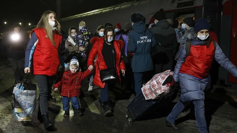 Orang-orang dari wilayah Donetsk dan Luhansk, wilayah yang dikuasai oleh pemerintah separatis pro-Rusia di Ukraina timur, berjalan kaki dari kereta api untuk dibawa ke tempat tinggal sementara di wilayah Volgograd, di stasiun kereta api di Volzhsky, wilayah Volgograd, Rusia, pada Minggu, 20 Februari 2022. (REUTERS/VLADIMIR LAVROV)
