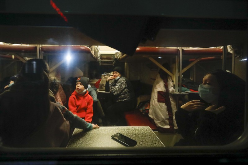 Orang-orang dari wilayah Donetsk dan Luhansk, wilayah yang dikuasai oleh pemerintah separatis pro-Rusia di Ukraina timur, berjalan kaki dari kereta api untuk dibawa ke tempat tinggal sementara di wilayah Volgograd, di stasiun kereta api di Volzhsky, wilayah Volgograd, Rusia, pada Minggu, 20 Februari 2022. (REUTERS/VLADIMIR LAVROV)