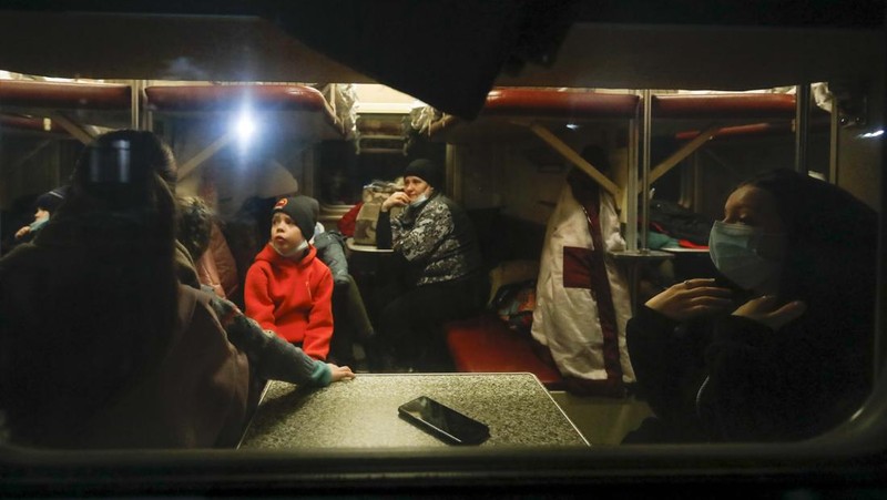 Orang-orang dari wilayah Donetsk dan Luhansk, wilayah yang dikuasai oleh pemerintah separatis pro-Rusia di Ukraina timur, berjalan kaki dari kereta api untuk dibawa ke tempat tinggal sementara di wilayah Volgograd, di stasiun kereta api di Volzhsky, wilayah Volgograd, Rusia, pada Minggu, 20 Februari 2022. (REUTERS/VLADIMIR LAVROV)