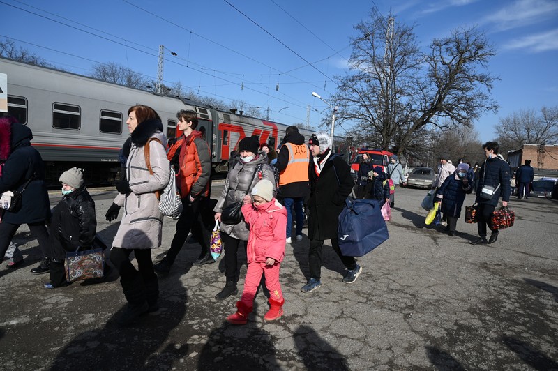 Orang-orang dari wilayah Donetsk dan Luhansk, wilayah yang dikuasai oleh pemerintah separatis pro-Rusia di Ukraina timur, berjalan kaki dari kereta api untuk dibawa ke tempat tinggal sementara di wilayah Volgograd, di stasiun kereta api di Volzhsky, wilayah Volgograd, Rusia, pada Minggu, 20 Februari 2022. (REUTERS/VLADIMIR LAVROV)
