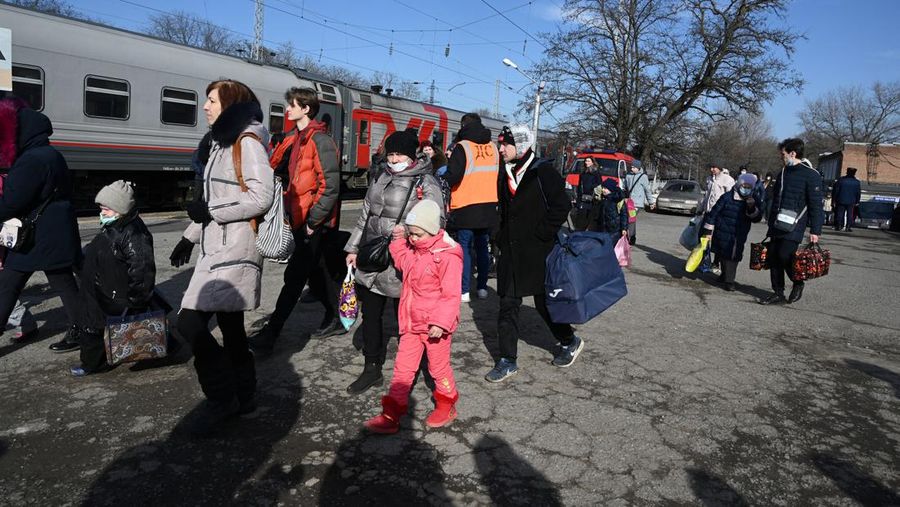 Orang-orang dari wilayah Donetsk dan Luhansk, wilayah yang dikuasai oleh pemerintah separatis pro-Rusia di Ukraina timur, berjalan kaki dari kereta api untuk dibawa ke tempat tinggal sementara di wilayah Volgograd, di stasiun kereta api di Volzhsky, wilayah Volgograd, Rusia, pada Minggu, 20 Februari 2022. (REUTERS/VLADIMIR LAVROV)
