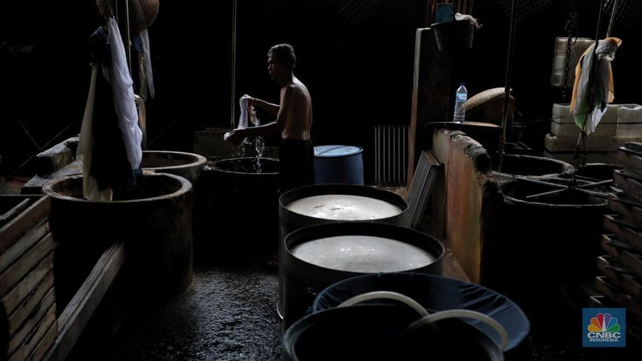 Pekerja membersihkan alat pembuatan tahu di tempat kerjanya ketika melakukan mogok produksi di pabrik tahu di kawasan Duren Tiga, Jakarta Selatan, Senin (21/2/2022). (CNBC Indonesia/Andrean Kristianto)