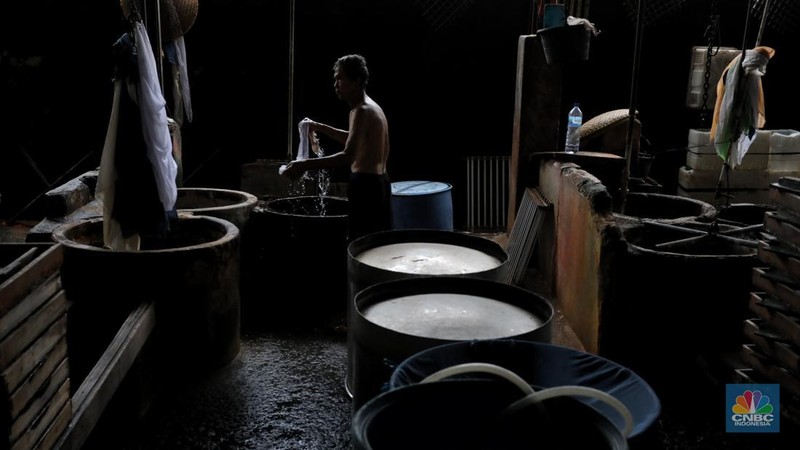 Pekerja membersihkan alat pembuatan tahu di tempat kerjanya ketika melakukan mogok produksi di pabrik tahu di kawasan Duren Tiga, Jakarta Selatan, Senin (21/2/2022). (CNBC Indonesia/Andrean Kristianto)