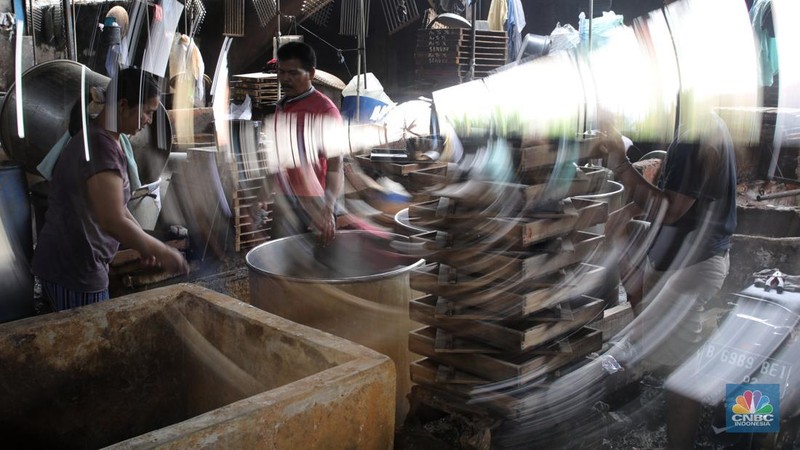 Pekerja membersihkan alat pembuatan tahu di tempat kerjanya ketika melakukan mogok produksi di pabrik tahu di kawasan Duren Tiga, Jakarta Selatan, Senin (21/2/2022). (CNBC Indonesia/Andrean Kristianto)