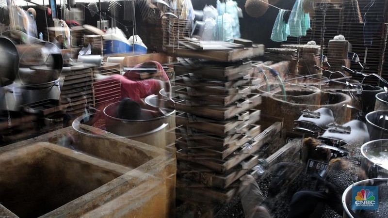 Pekerja membersihkan alat pembuatan tahu di tempat kerjanya ketika melakukan mogok produksi di pabrik tahu di kawasan Duren Tiga, Jakarta Selatan, Senin (21/2/2022). (CNBC Indonesia/Andrean Kristianto)