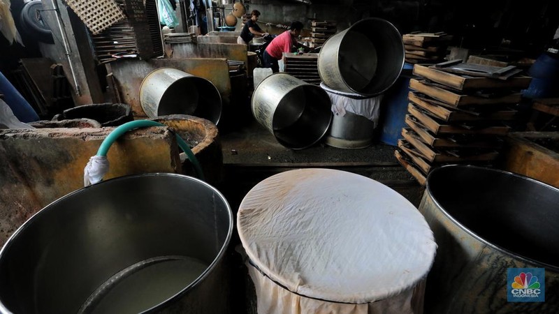 Pekerja membersihkan alat pembuatan tahu di tempat kerjanya ketika melakukan mogok produksi di pabrik tahu di kawasan Duren Tiga, Jakarta Selatan, Senin (21/2/2022). (CNBC Indonesia/Andrean Kristianto)