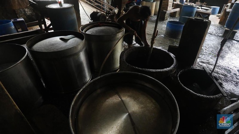 Pekerja membersihkan alat pembuatan tahu di tempat kerjanya ketika melakukan mogok produksi di pabrik tahu di kawasan Duren Tiga, Jakarta Selatan, Senin (21/2/2022). (CNBC Indonesia/Andrean Kristianto)