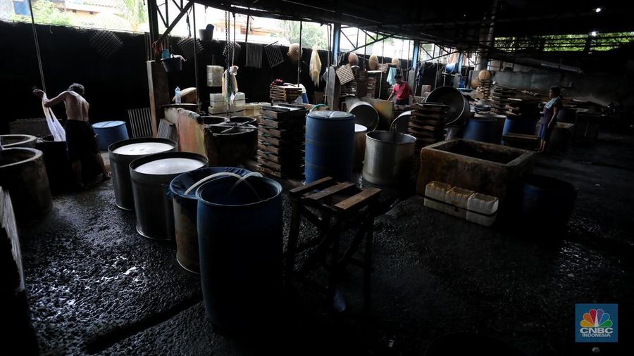 Pekerja membersihkan alat pembuatan tahu di tempat kerjanya ketika melakukan mogok produksi di pabrik tahu di kawasan Duren Tiga, Jakarta Selatan, Senin (21/2/2022). (CNBC Indonesia/Andrean Kristianto)