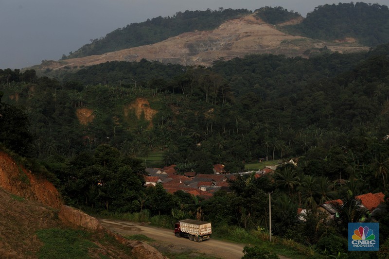 Truk pengangkut material melintas diantara gunungan tambang galian c batu andesit dan turunannya, termasuk pasir di kawasan Rumpin, Bogor, Jawa Barat, Senin, (21/2/2022). (CNBC Indonesia/Muhammad Sabki)