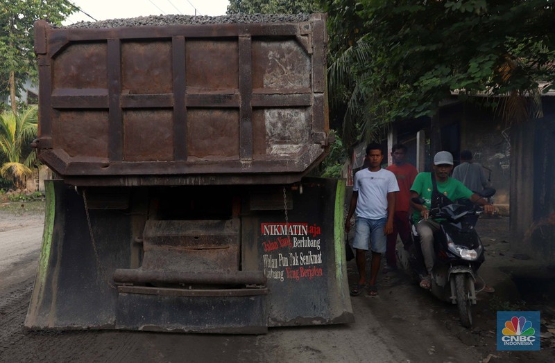 Truk pengangkut material melintas diantara gunungan tambang galian c batu andesit dan turunannya, termasuk pasir di kawasan Rumpin, Bogor, Jawa Barat, Senin, (21/2/2022). (CNBC Indonesia/Muhammad Sabki)