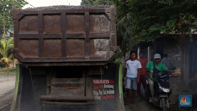 Truk pengangkut material melintas diantara gunungan tambang galian c batu andesit dan turunannya, termasuk pasir di kawasan Rumpin, Bogor, Jawa Barat, Senin, (21/2/2022). (CNBC Indonesia/Muhammad Sabki)