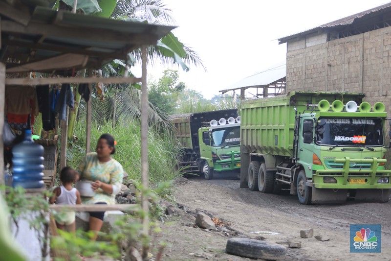 Truk pengangkut material melintas diantara gunungan tambang galian c batu andesit dan turunannya, termasuk pasir di kawasan Rumpin, Bogor, Jawa Barat, Senin, (21/2/2022). (CNBC Indonesia/Muhammad Sabki)