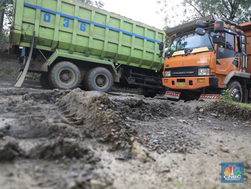 Truk pengangkut material melintas diantara gunungan tambang galian c batu andesit dan turunannya, termasuk pasir di kawasan Rumpin, Bogor, Jawa Barat, Senin, (21/2/2022). (CNBC Indonesia/Muhammad Sabki)
