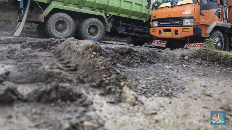 Truk pengangkut material melintas diantara gunungan tambang galian c batu andesit dan turunannya, termasuk pasir di kawasan Rumpin, Bogor, Jawa Barat, Senin, (21/2/2022). (CNBC Indonesia/Muhammad Sabki)