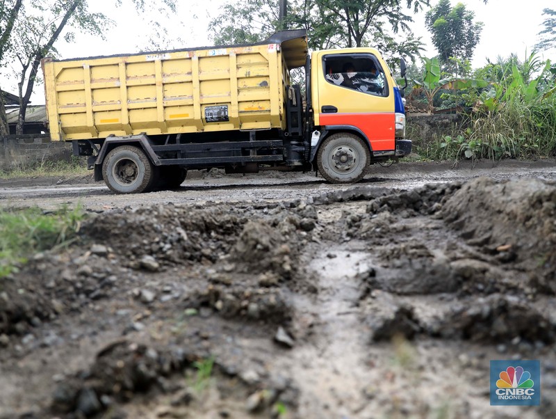 Truk pengangkut material melintas diantara gunungan tambang galian c batu andesit dan turunannya, termasuk pasir di kawasan Rumpin, Bogor, Jawa Barat, Senin, (21/2/2022). (CNBC Indonesia/Muhammad Sabki)