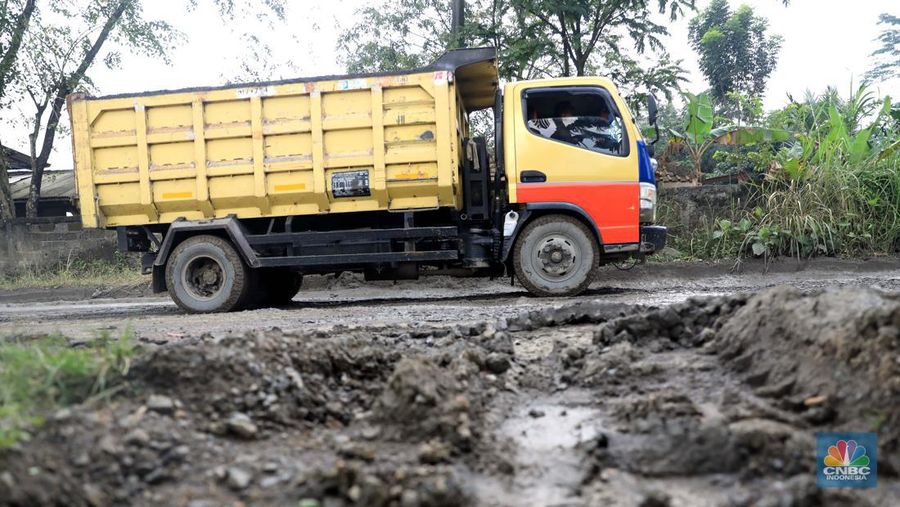 Truk pengangkut material melintas diantara gunungan tambang galian c batu andesit dan turunannya, termasuk pasir di kawasan Rumpin, Bogor, Jawa Barat, Senin, (21/2/2022). (CNBC Indonesia/Muhammad Sabki)