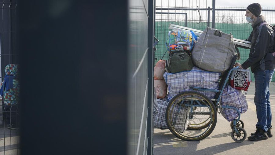 Ratusan menyeberang dari wilayah yang dikuasai separatis pro-Rusia ke wilayah yang dikuasai pemerintah Ukraina di Stanytsia Luhanska, satu-satunya titik penyeberangan yang buka setiap hari, di wilayah Luhansk, Ukraina timur, Selasa, 22 Februari 2022. (AP/Vadim Ghirda)