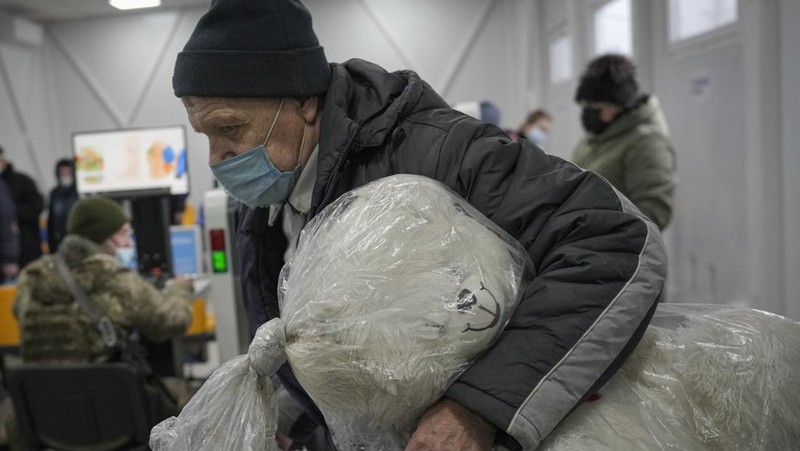 Ratusan menyeberang dari wilayah yang dikuasai separatis pro-Rusia ke wilayah yang dikuasai pemerintah Ukraina di Stanytsia Luhanska, satu-satunya titik penyeberangan yang buka setiap hari, di wilayah Luhansk, Ukraina timur, Selasa, 22 Februari 2022. (AP/Vadim Ghirda)