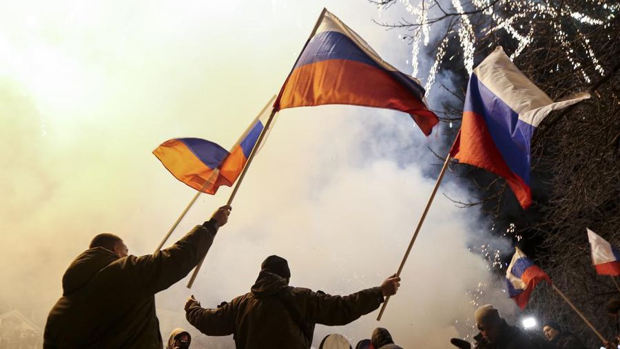 Warga di Donetsk dan Luhansk berarak di jalanan untuk merayakan pengakuan Rusia atas kemerdekaan wilayah yang dikuasai separatis di timur Ukraina tersebut pada Senin (21/2). (AP Photo/Alexei Alexandrov)