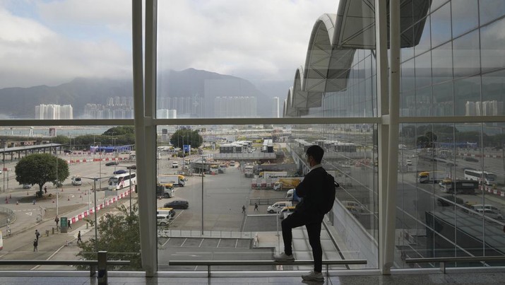 Seorang warga berdiri menghadap Hong Kong airport yang sepi akibat lonjakan kasus Covid-19 (AP/Kin Cheung)