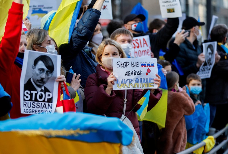 Warga Ukraina yang tinggal di Jepang berdemo memegang plakat dan bendera selama demonstrasi mengecam Rusia atas tindakannya atas Ukraina, di kedutaan Rusia di Tokyo, Jepang, Rabu (23/2/2022). (REUTERS/ISSEI KATO)