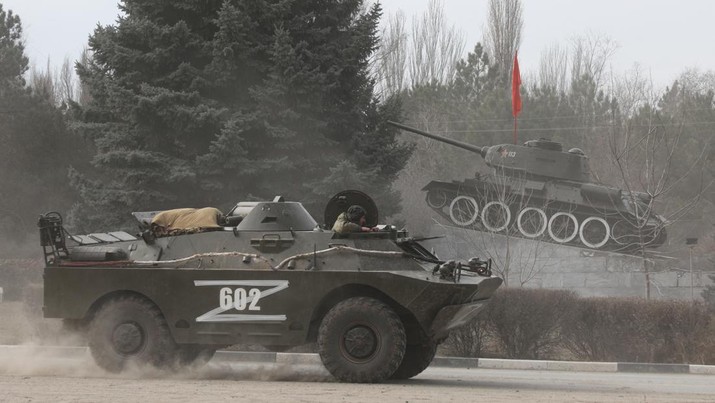 Sebuah kendaraan lapis baja dengan huruf 'Z' di atasnya melewati monumen yang menampilkan tank era Soviet, setelah Presiden Rusia Vladimir Putin mengizinkan operasi militer di Ukraina timur, di kota Armyansk, Krimea, 24 Februari 2022. (REUTERS/STRINGER)