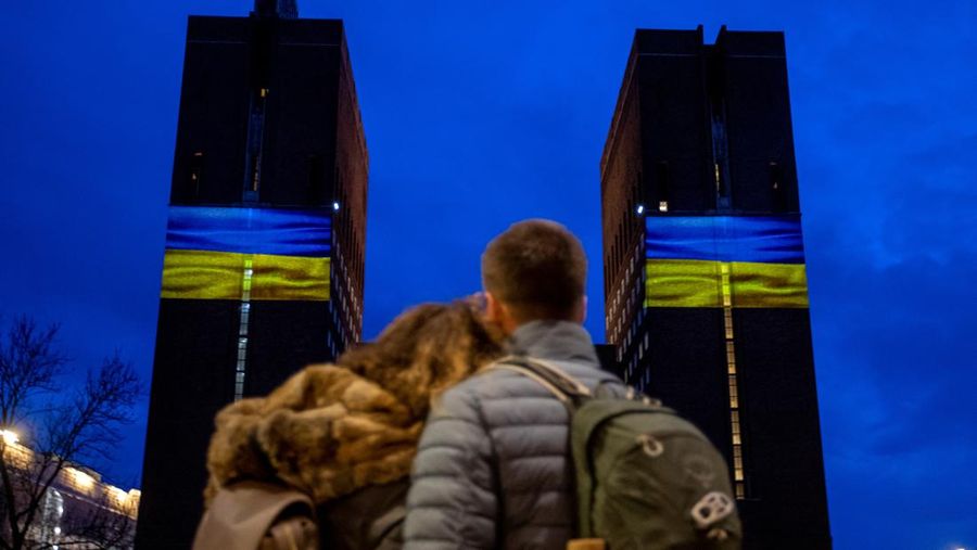 Demonstran pro-Ukraina mengibarkan bendera besar Ukraina di Times Square New York, Kamis, 24 Februari 2022. (AP/Seth Wenig)