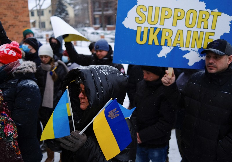 Demonstran pro-Ukraina mengibarkan bendera besar Ukraina di Times Square New York, Kamis, 24 Februari 2022. (AP/Seth Wenig)