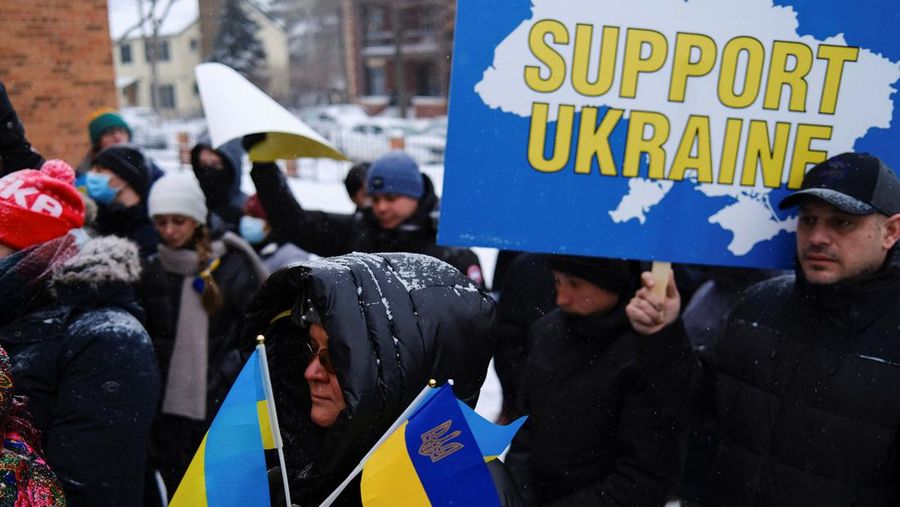 Demonstran pro-Ukraina mengibarkan bendera besar Ukraina di Times Square New York, Kamis, 24 Februari 2022. (AP/Seth Wenig)