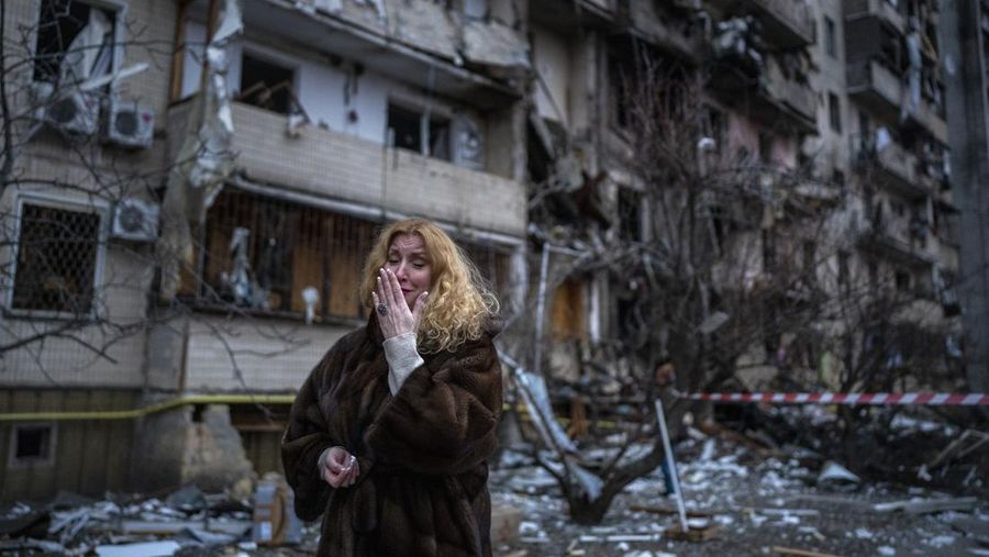 Reaksi Natali Sevriukova di samping rumahnya menyusul serangan roket di kota Kyiv, Ukraina, Jumat, (25/2/2022). (AP/Emilio Morenatti)