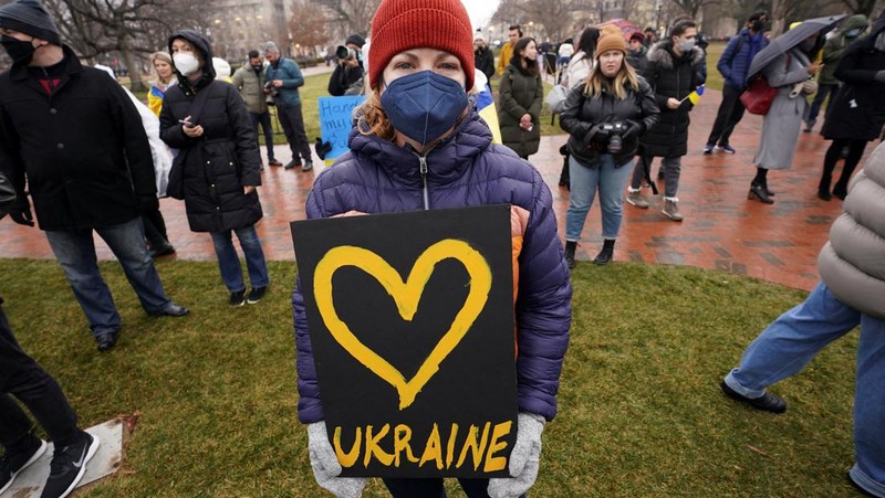 Demonstran pro-Ukraina mengibarkan bendera besar Ukraina di Times Square New York, Kamis, 24 Februari 2022. (AP/Seth Wenig)