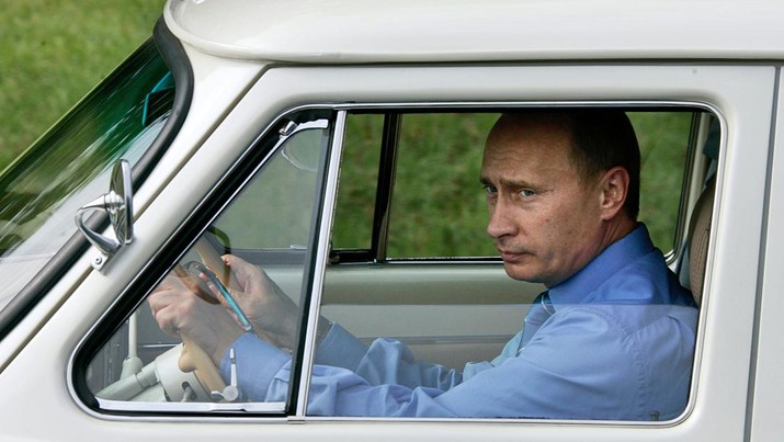 Russian President Vladimir Putin drives his 1956 white Volga as he arrives at the opening ceremony of a new tunnel on a highway leading from the Black Sea resort of Sochi to a mountain skiing resort, Friday, Aug. 19, 2005. (AP Photo/ITAR-TASS, Presidential Press Service)