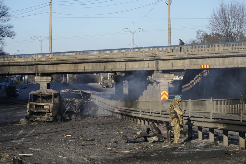 Tentara Ukraina mengambil posisi di luar fasilitas militer saat dua mobil terbakar, di sebuah jalan di Kyiv, Ukraina, Sabtu (26/2/2022). Pasukan Rusia menyerbu ke arah ibu kota Ukraina dan pertempuran jalanan pecah saat pejabat kota mendesak penduduk untuk berlindung. (AP/Emilio Morenatti) Tentara Ukraina mengambil posisi di luar fasilitas militer saat dua mobil terbakar, di sebuah jalan di Kyiv, Ukraina, Sabtu (26/2/2022). Pasukan Rusia menyerbu ke arah ibu kota Ukraina dan pertempuran jalanan pecah saat pejabat kota mendesak penduduk untuk berlindung. (AP/Emilio Morenatti)