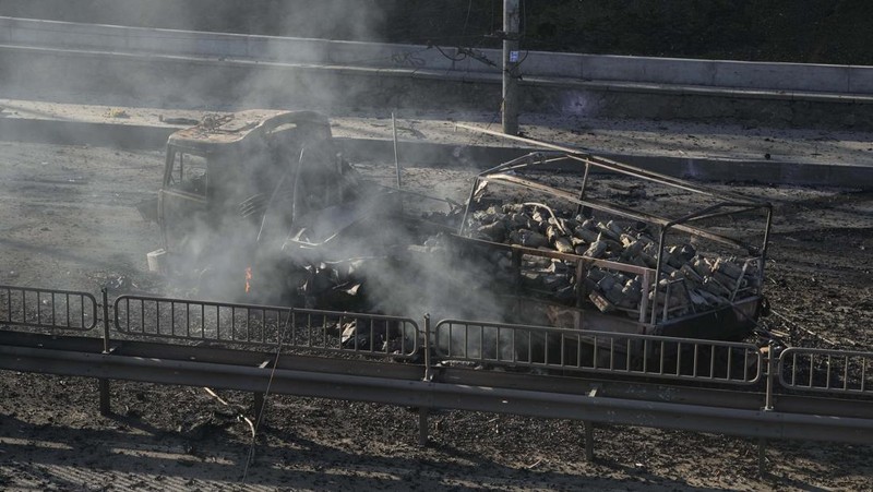 Tentara Ukraina mengambil posisi di luar fasilitas militer saat dua mobil terbakar, di sebuah jalan di Kyiv, Ukraina, Sabtu (26/2/2022). Pasukan Rusia menyerbu ke arah ibu kota Ukraina dan pertempuran jalanan pecah saat pejabat kota mendesak penduduk untuk berlindung. (AP/Emilio Morenatti)