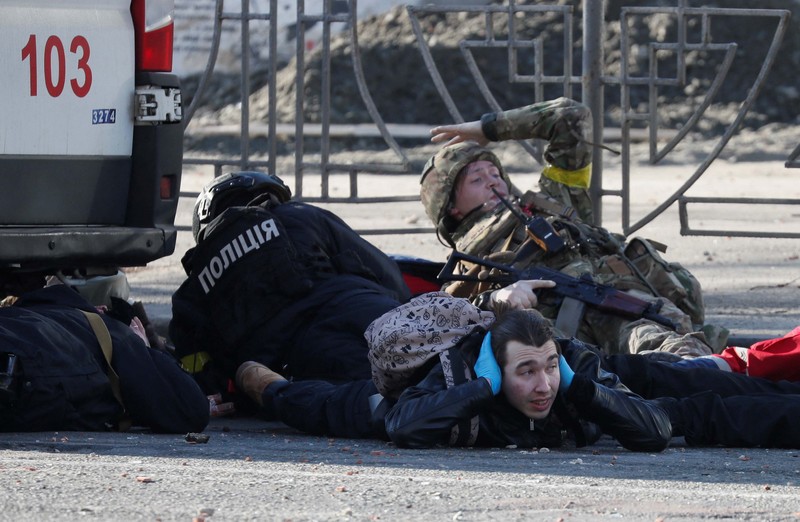 Tentara Ukraina mengambil posisi di luar fasilitas militer saat dua mobil terbakar, di sebuah jalan di Kyiv, Ukraina, Sabtu (26/2/2022). Pasukan Rusia menyerbu ke arah ibu kota Ukraina dan pertempuran jalanan pecah saat pejabat kota mendesak penduduk untuk berlindung. (AP/Emilio Morenatti) Tentara Ukraina mengambil posisi di luar fasilitas militer saat dua mobil terbakar, di sebuah jalan di Kyiv, Ukraina, Sabtu (26/2/2022). Pasukan Rusia menyerbu ke arah ibu kota Ukraina dan pertempuran jalanan pecah saat pejabat kota mendesak penduduk untuk berlindung. (AP/Emilio Morenatti)