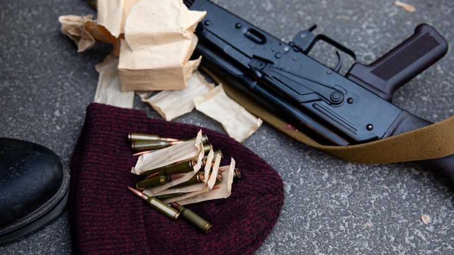 Presiden Ukraina, Volodymyr Zelensky telah memerintahkan dekrit mobilisasi massa yang membuka jalan bagi warga sipil untuk mengangkat senjata melawan pasukan Rusia yang dipimpin Vladimir Putin. A view shows ammunition and an assault rifle as members of the Territorial Defence Forces of Ukraine receive weapons to defend the city of Kyiv, Ukraine February 25, 2022. (Mikhail Palinchak/Pool via REUTERS)