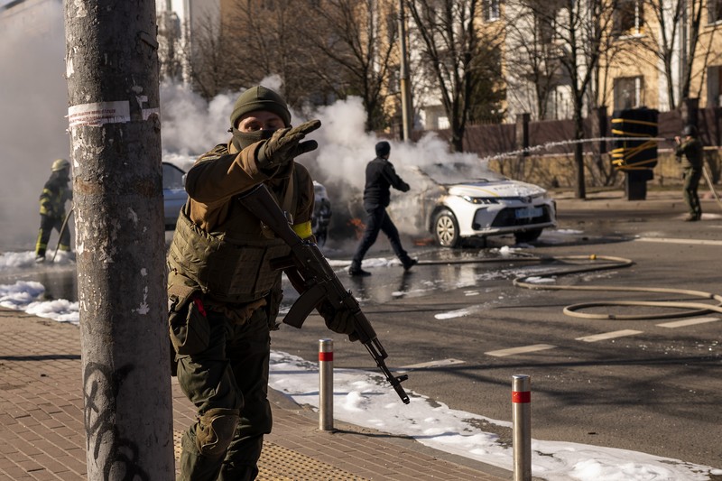 Tentara Ukraina mengambil posisi di luar fasilitas militer saat dua mobil terbakar, di sebuah jalan di Kyiv, Ukraina, Sabtu (26/2/2022). Pasukan Rusia menyerbu ke arah ibu kota Ukraina dan pertempuran jalanan pecah saat pejabat kota mendesak penduduk untuk berlindung. (AP/Emilio Morenatti) Tentara Ukraina mengambil posisi di luar fasilitas militer saat dua mobil terbakar, di sebuah jalan di Kyiv, Ukraina, Sabtu (26/2/2022). Pasukan Rusia menyerbu ke arah ibu kota Ukraina dan pertempuran jalanan pecah saat pejabat kota mendesak penduduk untuk berlindung. (AP/Emilio Morenatti)