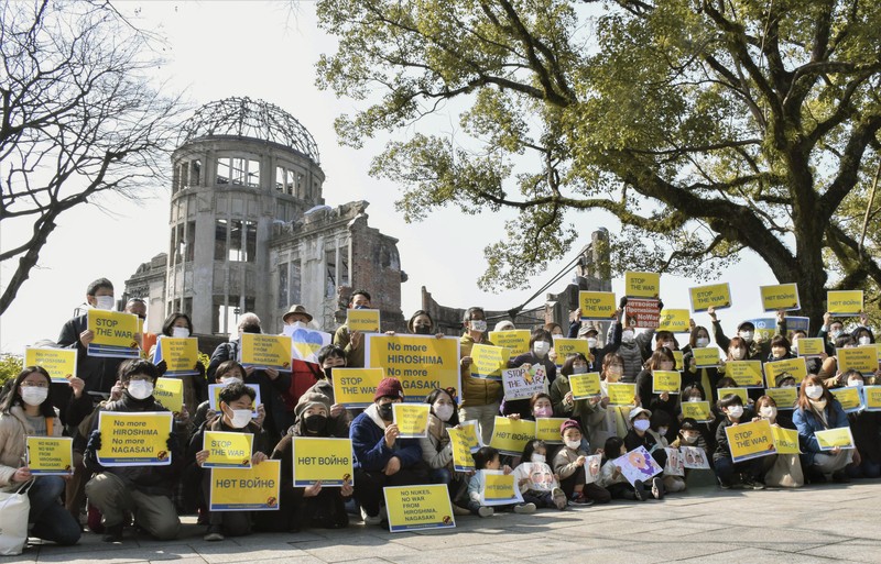 Para wanita membantu mengangkat bendera nasional Ukraina saat mereka memprotes invasi Rusia ke Ukraina, di Buenos Aires, Argentina. Jumat (25/2/2022).  (AP Photo'/Natacha Pisarenko)