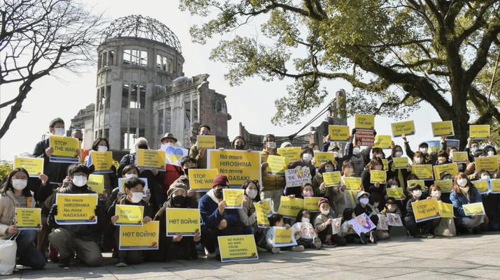 Demo Tolak Invasi Rusia Terhadap Ukraina di Hiroshima, Jepang barat Orang-orang menunjukkan poster bertuliskan,