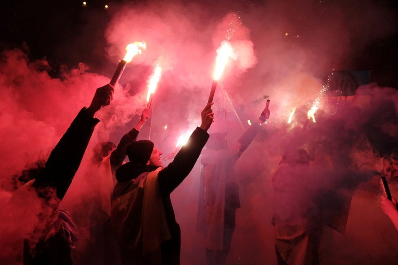 Demo Tolak Invasi Rusia Terhadap Ukraina di Buenos Aires, Argentina Para wanita membantu mengangkat bendera nasional Ukraina saat mereka memprotes invasi Rusia ke Ukraina, di Buenos Aires, Argentina. Jumat (25/2/2022). (AP Photo'/Natacha Pisarenko)
