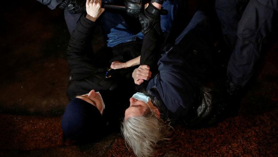 Para wanita membantu mengangkat bendera nasional Ukraina saat mereka memprotes invasi Rusia ke Ukraina, di Buenos Aires, Argentina. Jumat (25/2/2022).  (AP Photo'/Natacha Pisarenko)