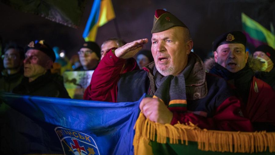 People take part in a protest against Russian invasion of Ukraine, in Vilnius, Lithuania, Thursday, Feb. 24, 2022. Russian troops launched a wide-ranging attack on Ukraine on Thursday, as President Vladimir Putin cast aside international condemnation and sanctions and warned other countries that any attempt to interfere would lead to 