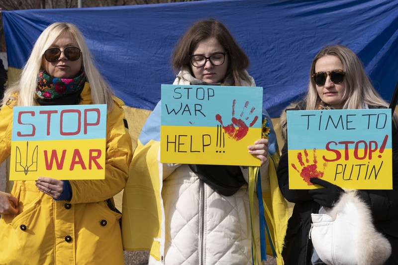 Demo Tolak Invasi Rusia Terhadap Ukraina di Buenos Aires, Argentina Para wanita membantu mengangkat bendera nasional Ukraina saat mereka memprotes invasi Rusia ke Ukraina, di Buenos Aires, Argentina. Jumat (25/2/2022). (AP Photo'/Natacha Pisarenko)