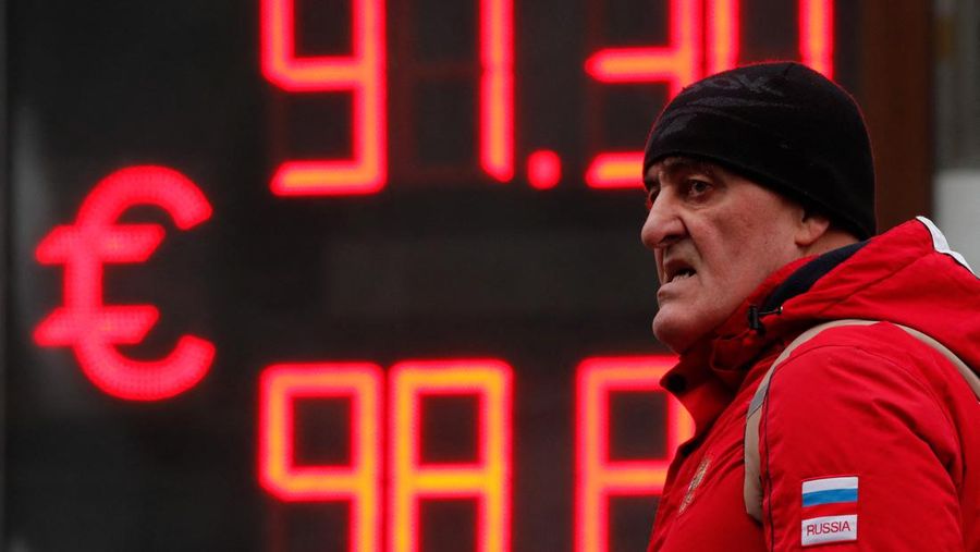 Seorang pria berjalan melewati papan yang menunjukkan nilai tukar mata uang euro terhadap rubel Rusia di sebuah jalan di Saint Petersburg, Rusia (25/2/2022). (REUTERS/Anton Vaganov)