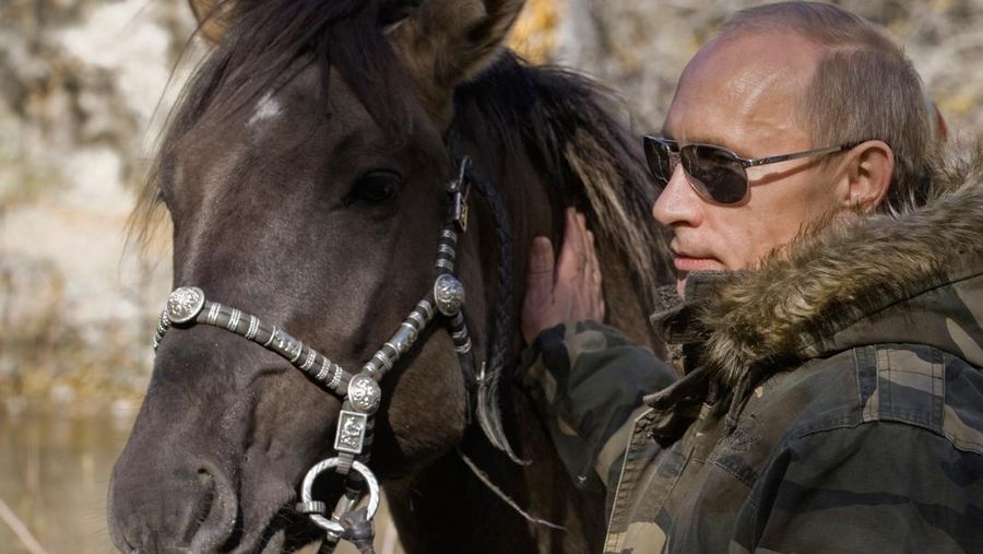 In this Sept. 2010 photo released on Saturday, Oct. 30, 2010, Russian Prime Minister Vladimir Putin pats a horse during his trip in Ubsunur Hollow in the Siberian Tyva region (also referred to as Tuva), on the border with Mongolia, Russia. (AP Photo/RIA Novosti, Alexei Druzhinin, Pool)