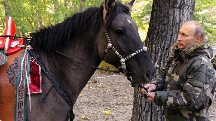 In this Sept. 2010 photo released on Saturday, Oct. 30, 2010, Russian Prime Minister Vladimir Putin pats a horse during his trip in Ubsunur Hollow in the Siberian Tyva region (also referred to as Tuva), on the border with Mongolia, Russia. (AP Photo/RIA Novosti, Alexei Druzhinin, Pool)