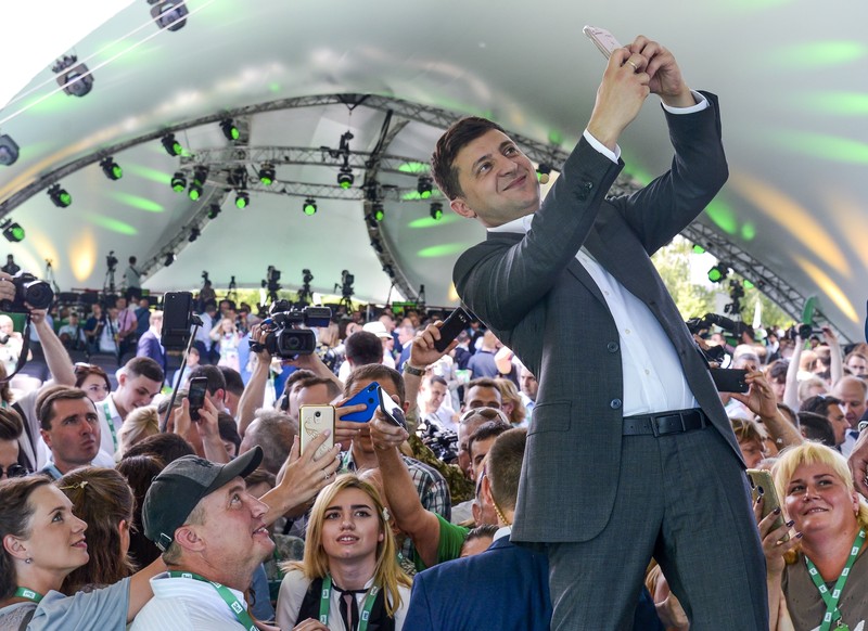 Presiden Ukraina Volodymyr Zelensky FILE - In this Friday, March 29, 2019 file photo, Volodymyr Zelenskiy, Ukrainian actor and candidate in the upcoming presidential election, hosts a comedy show at a concert hall in Brovary, Ukraine. For his presidential campaign popular Ukrainian comedian Volodymyr Zelenskiy has literally taken the script from a TV show in which he plays the Ukrainian president. (AP Photo/Efrem Lukatsky, file)